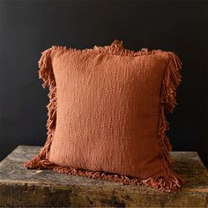 a brown pillow sitting on top of a wooden block