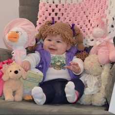 a baby sitting in a chair surrounded by stuffed animals