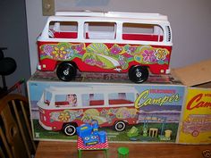 a toy bus sitting on top of a wooden table next to other toys and boxes