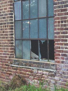 an old brick building with a broken window