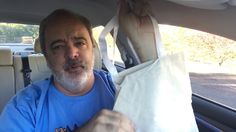 a man sitting in the back seat of a car holding onto a paper bag that he is holding