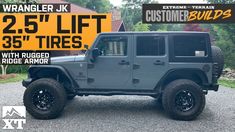 a gray jeep parked on top of a gravel road next to a yellow and black sign