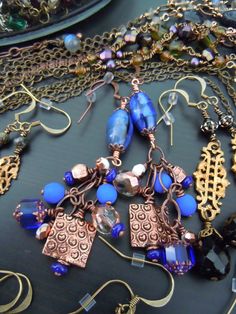 a close up of a necklace on a table with other jewelry and bracelets hanging from it