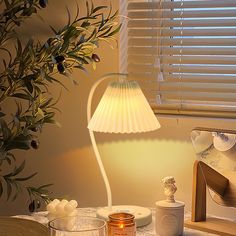 a lamp that is sitting on top of a table next to some jars and candles