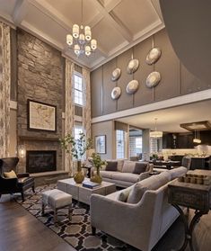 a living room filled with furniture and a fire place in the middle of an open floor plan