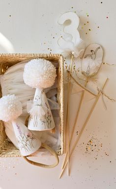 a box filled with white pom poms next to other items