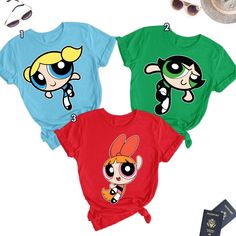 the powerpuff girls t - shirts are on display next to sunglasses and a passport