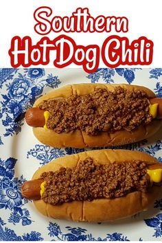 two hot dogs on buns with chili and mustard sitting on a blue and white plate