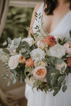 a bridal holding a bouquet of flowers and greenery