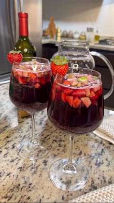 two glasses filled with liquid sitting on top of a counter