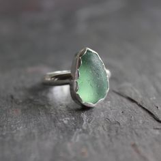 a green ring sitting on top of a piece of wood next to a wooden table