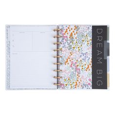 an open planner book with flowers on the cover and black lettering that says dream big