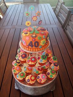 there is a cake and cupcakes on the wooden table with it's number forty