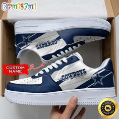 a pair of sneakers with the word cowboys on them in a box and an image of someone's hand next to it