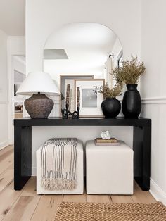 a black and white console table with two vases on it