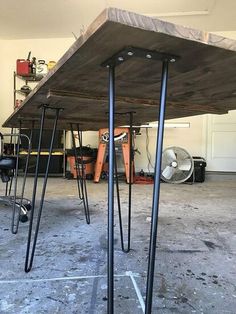 two tables with metal legs in a garage