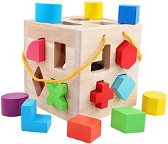 a wooden block toy with colorful shapes and colors on the front, along with smaller blocks