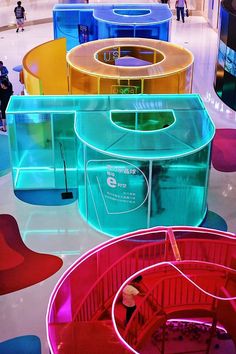 colorful plastic containers are stacked on top of each other in the middle of a room