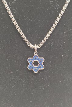 Small sterling silver and blue star of David necklace Width: 1CM Height: 1 1/2CM Chain length: 24IN Blue Star Charm Pendant Necklace, Blue Pendant Necklace With Star Charm, Silver Star Of David Charm Jewelry, Sterling Silver Jewelry Pendant With Star Charm, Sterling Silver Star Necklace In Silver, Sterling Silver Star-shaped Jewelry, Sterling Silver Star Necklace In White Gold, Blue Necklace With Star Charm As A Gift, White Gold Star Necklace In Sterling Silver