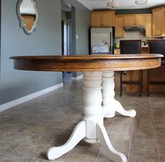 a kitchen with a table in the middle and tile flooring on the other side