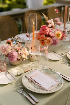 the table is set with flowers and candles