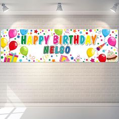 a happy birthday banner with balloons and confetti on a white brick wall background