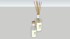 two bottles with reeds in them sitting next to each other on a gray surface