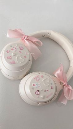 two white headphones with pink bows on the ears and one has an embellishment