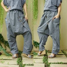 "Extravagant cotton chambray pants, avant garde pants, unisex harem pants, drop crotch pants, loose casual pants with 2 roomy patched pockets. I make these pants with elastic waist for comfort fit. Easy matching with any simple top. Material: 100% cotton chambray Status: ready to ship Model is 161 cm. tall with 28\" waist and 38\" hip Measurement: freesize pants (approximately) Elastic waist: 30\"-42\" (with adjustable drawstring) Hip: 54\" can fit up to hip max 50\" Total Length: 39.5\" (longes Summer Cotton Pants With Buttons, Cotton Tapered Leg Pants With Buttons, Cotton Lagenlook Bottoms With Pockets, Cotton Straight Pants With Buttons, Straight Cotton Pants With Buttons, Lagenlook Harem Pants With Pockets, Cotton Harem Pants For Spring, Bohemian Cotton Tapered Leg Pants, Cotton Ankle-length Lagenlook Pants