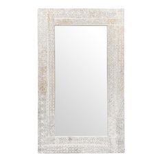 a white framed mirror with an intricate design on the front and bottom edge, against a white background