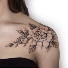 a woman's shoulder with a rose tattoo on it