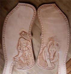 pair of cowboy boots with horse and rider design on the soles, sitting on wooden floor