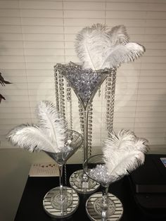 two wine glasses with silver feathers in them