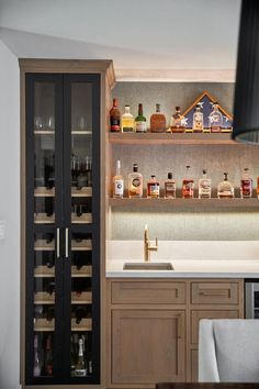 a kitchen filled with lots of bottles and cabinets