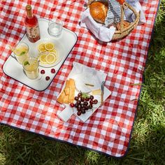 a picnic blanket with food and drinks on it