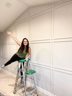 a woman is sitting on a ladder and posing for the camera with her arms outstretched