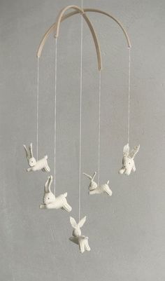 a mobile with white rabbits hanging from it's sides