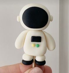 a small white and black toy in someone's hand