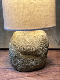 a rock lamp sitting on top of a wooden floor