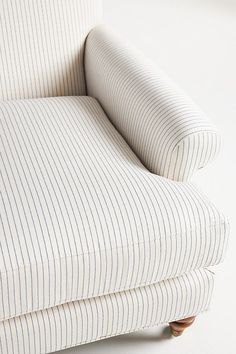 a white and blue striped couch with wooden legs