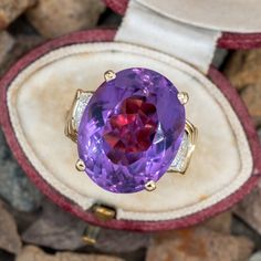 This amethyst cocktail ring is centered with one (1) oval mixed cut natural amethyst set into a four-prong setting. The shoulders of the ring are each accented with five (5), bead set, round brilliant cut diamonds. The ring measures 20.0mm at the top, rises 12.1mm above the finger, tapering to 3.3mm wide and 0.9mm thick at the base of the shank. The ring is currently a size 5. Oval Amethyst Gemstones For Formal Occasions, Formal Oval Amethyst Gemstones, Formal Oval Cabochon Amethyst Ring, Purple Ruby Ring For Formal Occasions, Luxury Purple Oval Gemstones, Oval Amethyst Ring With Gemstone Accents For Formal Occasions, Luxury Purple Amethyst Oval Cabochon Ring, Purple Amethyst Oval Cabochon Ring, Heirloom Style Purple Oval Amethyst Ring