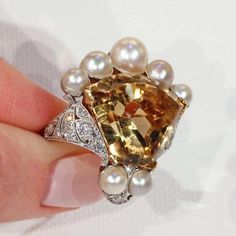 "I wanted something fun, something fresh, something subtle. Then I saw this pearly citrine crown ring and decided that \"subtle\" was no longer in my vocabulary. This piece is an assemblage of beauty, a collection of gems fit for a king. Honestly, I have no regrets. This regal ring features a large calf cut citrine stone topped with a crown of beautiful white pearls accented with diamonds. The stones in this ring are set in platinum with an 18 karat gold back and shank. The lively citrine is a v Elegant Open Citrine Ring, Elegant Open Ring Citrine Rings, Elegant Citrine Open Ring, Elegant Open Ring With Citrine, Luxury Pearl Ring With Rose Cut Diamonds For Anniversary, Luxury Cabochon Pearl Ring For Wedding, Elegant Topaz Ring For Anniversary, Luxury Cabochon Pearl Wedding Ring, Elegant Multi-stone Citrine Topaz Ring