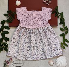 Description: * This light purple colored dress includes a hand knitted top with a soft floe skirt made out of material * The upper back of the dress is equipped with three small purple button for easy of putting the dress on baby. * The lower half of the dress is a white and small purple flowers. *  Material: Acrylic soft, cuddly, and durable yarn. Friendly to baby skin without any allergy. * We recommend hand washing this piece.  * This dress can be used for: baby shower gift, baby pictures, bi Crochet Baby Frock, Frock Models, Knit Summer Dress, Knit Summer, Baby Girls Dresses, Baby Cardigan Pattern, Baby Frock Pattern, Crochet Baby Cardigan, Frock Patterns