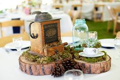 the table is set with pinecone and glass vases, which have succulents on them