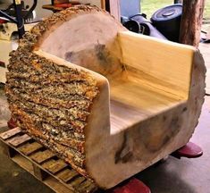 a chair made out of wood sitting on top of a pallet in a garage