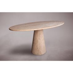 an oval marble table on a grey background with the top turned down to look like it is made out of plywood