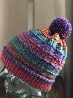 a multicolored knitted hat on top of a head