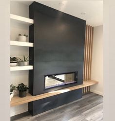 a modern fireplace with shelves and plants in the corner