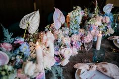 the table is set with flowers and candles