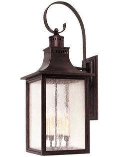 an outdoor wall light with three candles on it